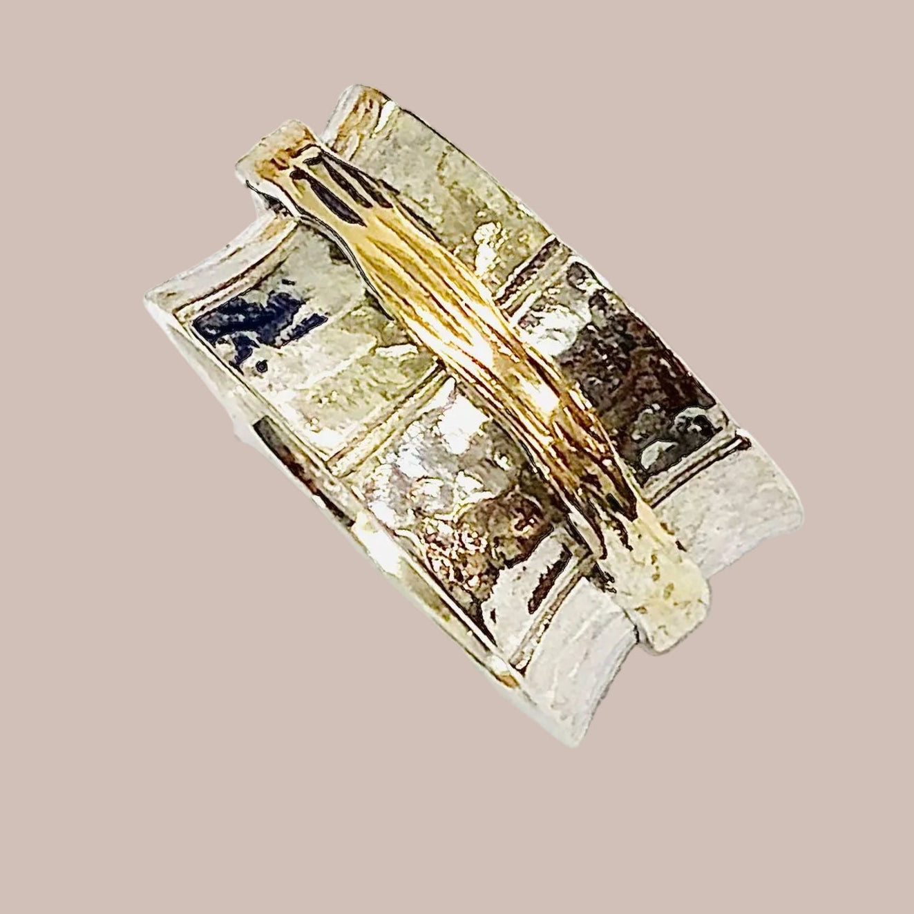 Gold and silver ring with embedded stones on a white background