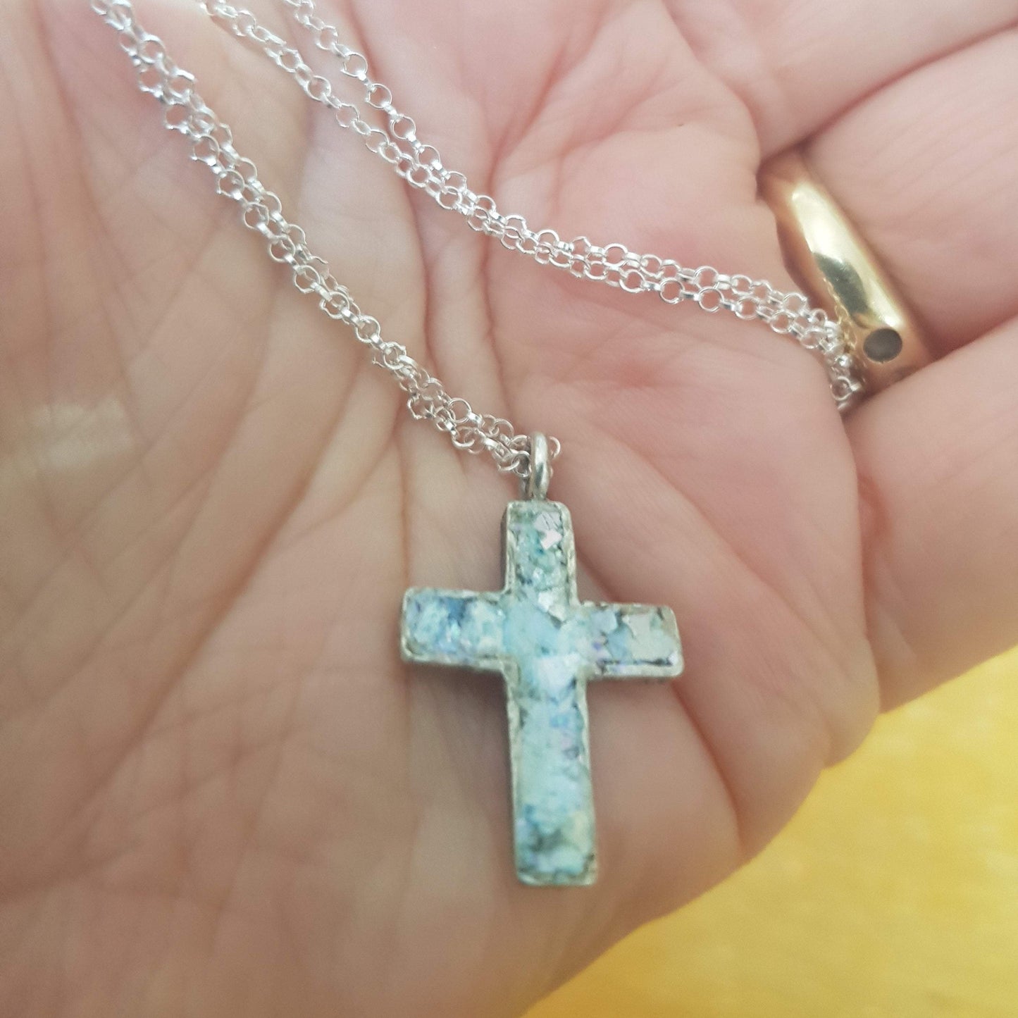 Sterling silver cross pendant set with aqua‑hued Roman glass fragment