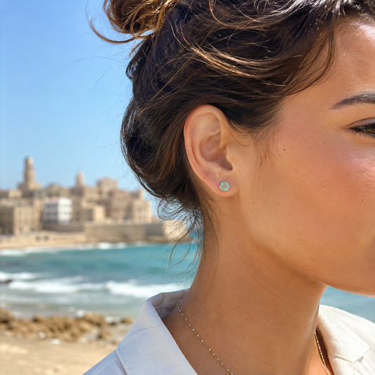 Woman wearing Roman glass earrings near Tel Aviv sea
