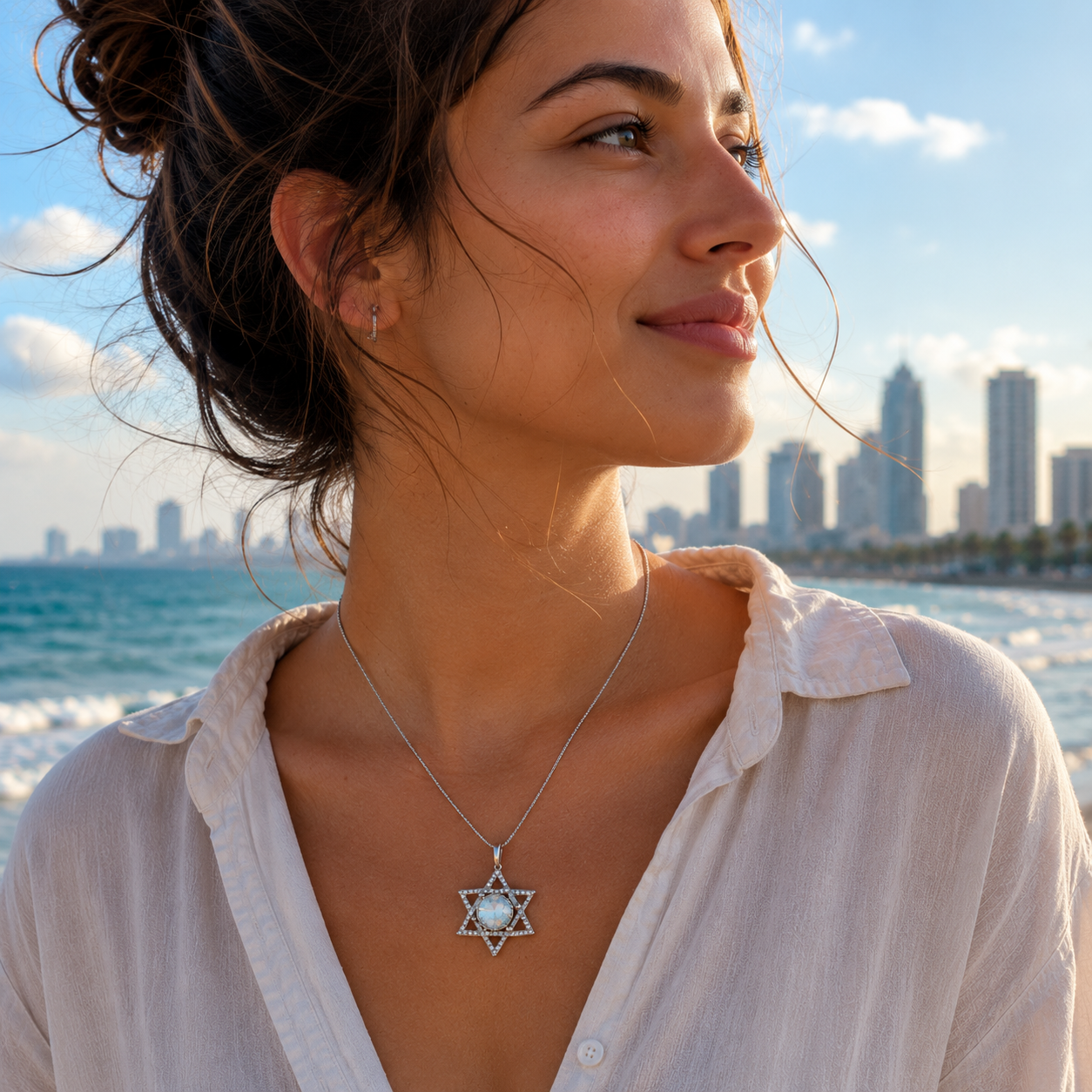 Woman wearing a Roman Glass necklace with a star pendant by the beach with city skyline in the background