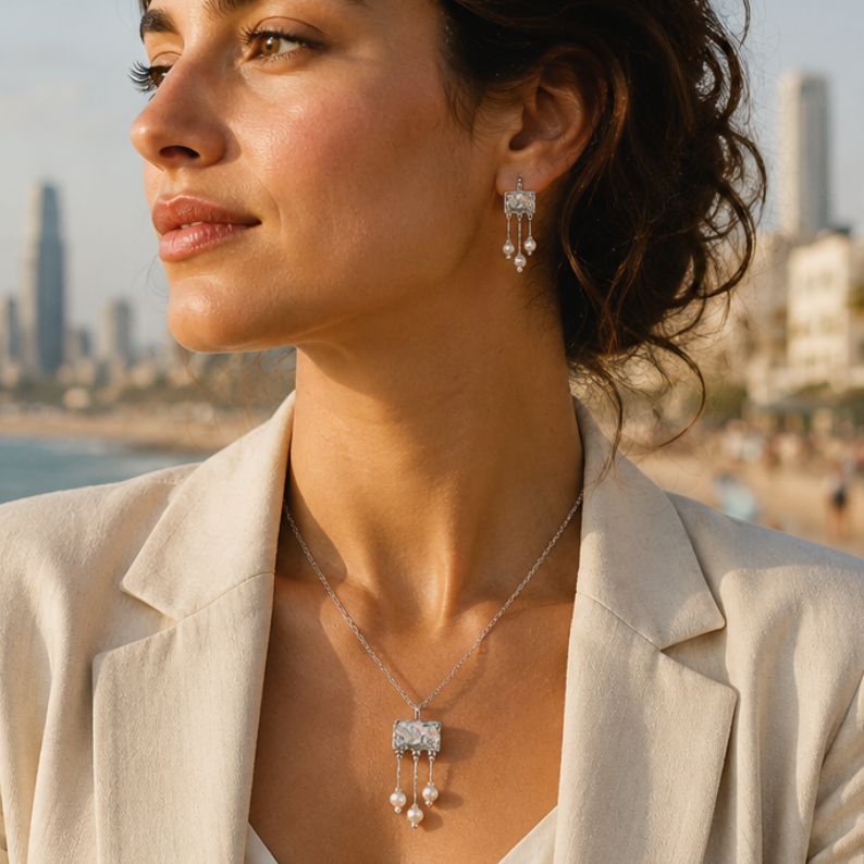 Woman standing on a beach with a city skyline in the background, wearing a necklace.