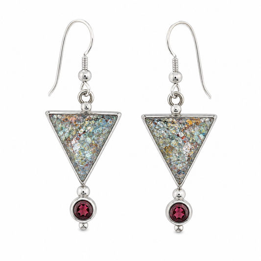 A pair of silver dangle earrings featuring inverted triangles filled with iridescent glitter and a small round faceted dark red gemstone hanging below, shown on a plain white background.