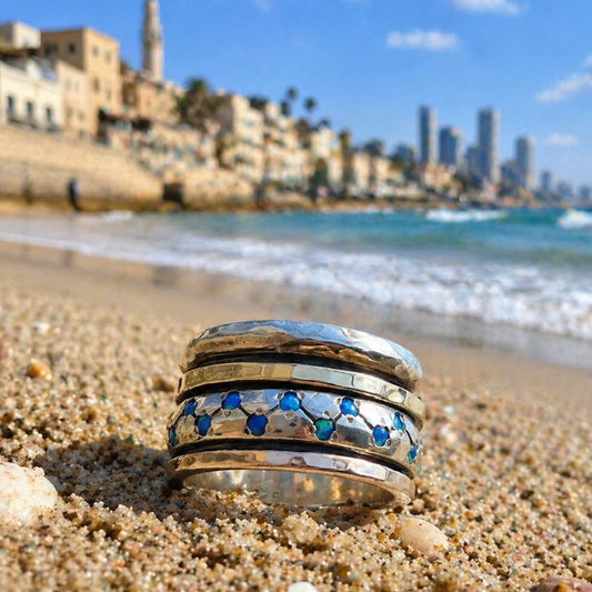 Spinner ring silver and gold blue opals near the sea