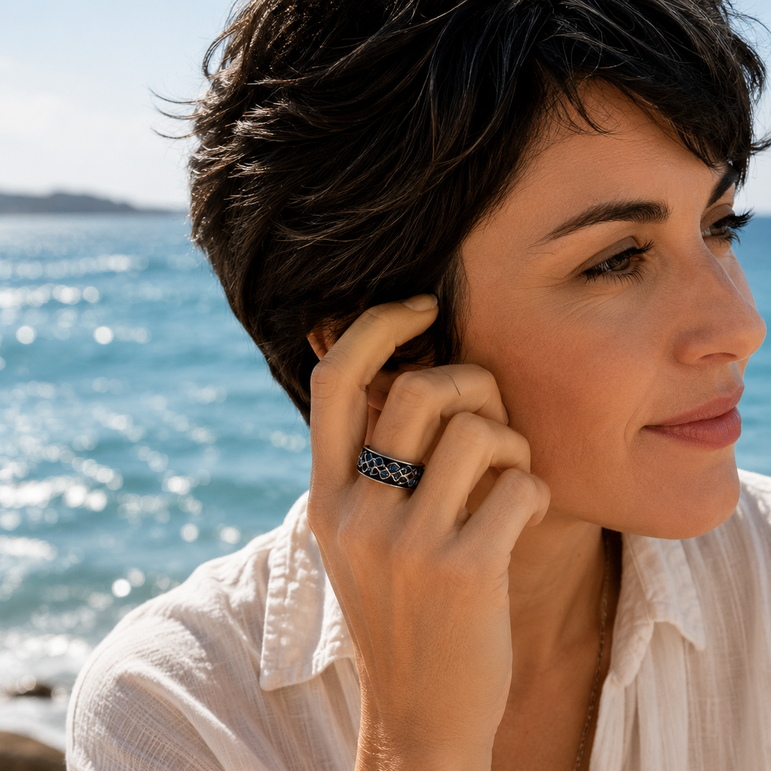 A spinner ring on the finer of a woman near the sea
