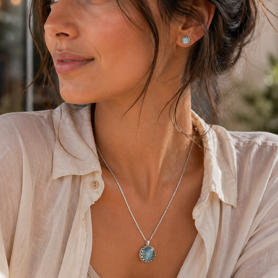 Woman wearing a necklace with a pendant in a softly lit indoor setting