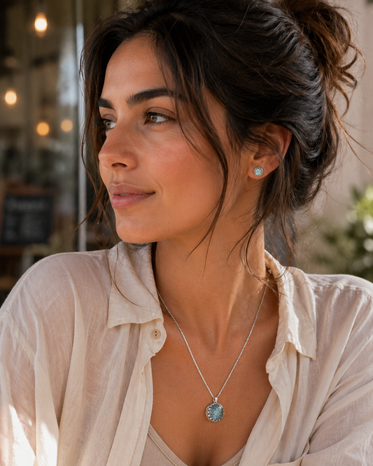 Woman wearing a necklace with a pendant in a softly lit indoor setting